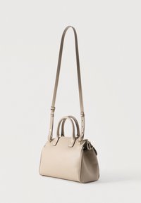 Μπεζ δερμάτινη τσάντα χειρός με πάνω λαβές και ρυθμιζόμενο μακρύ λουρί στον ώμο, εμφανίζεται μπροστά σε λευκό φόντο.