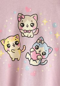 Un tessuto rosa presenta tre gatti cartoon: un gatto a strisce gialle e bianche, un gatto bianco con un fiocco rosa e un gatto blu che tiene un cuore, circondati da stelle e bolle.