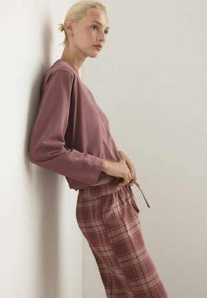 Long-sleeve, mauve top paired with plaid, pink and beige drawstring pants featuring a relaxed fit and soft texture.