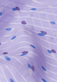 Tessuto viola con motivo a righe ondulate bianche e piccole gocce colorate in blu, azzurro, viola e bianco. Texture semi-trasparente.