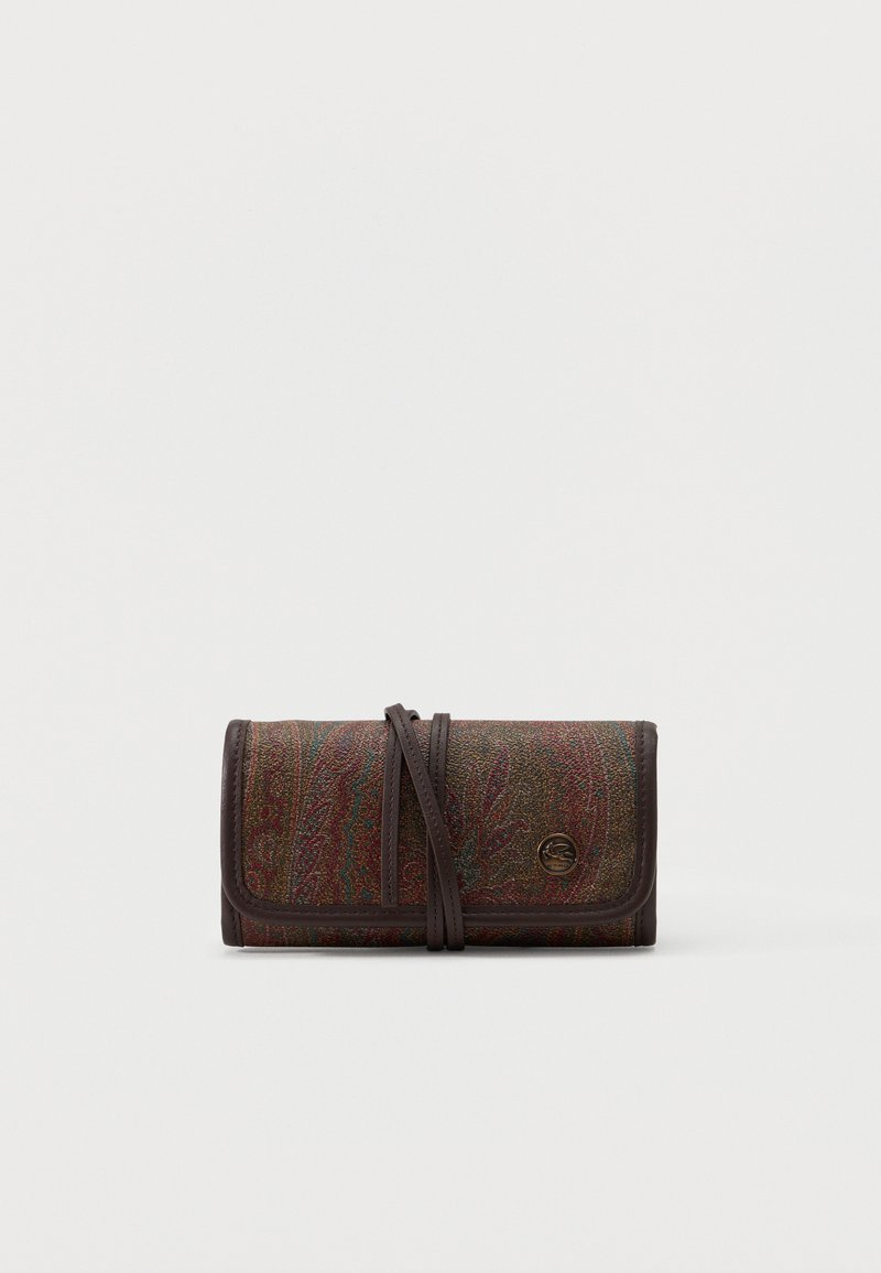 Pochette en tissu multicolore à motifs cachemire repliée, avec bordure en cuir marron et bandoulière en cuir enveloppante, ornée d'un petit emblème rond en métal avec logo.