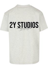 Grå bomulls T-skjorte med fet svart trykt tekst på baksiden som sier "2Y STUDIOS" og ekstra mindre tekst under.