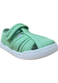 Zapatilla de lona de color verde claro con correas entrelazadas y un diseño de punta abierta. Presenta una suela de goma blanca con detalles de agarre texturizado.
