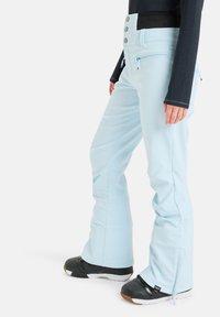 Jasnoniebieskie spodnie narciarskie o dopasowanej talii, czterema guzikami i kieszeniami na zamek. Materiał jest gładki o lekko błyszczącej teksturze.