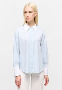 Helles blaues Langarmhemd mit weißen vertikalen Streifen, spitzem Kragen, Knopfleiste und weißen Ärmelakzenten. Glatte Stofftextur.