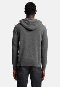Grau gestrickter Kapuzenpullover mit strukturiertem Finish, verstellbarer Kapuze und langen Ärmeln. Der Saum ist leicht gerippt und ergänzt das lässige Design.