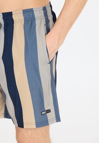 Gestreifte Badehose in Blau, Beige und Navy; elastischer Bund mit Kordelzug; Seitentasche; leichtes Material.