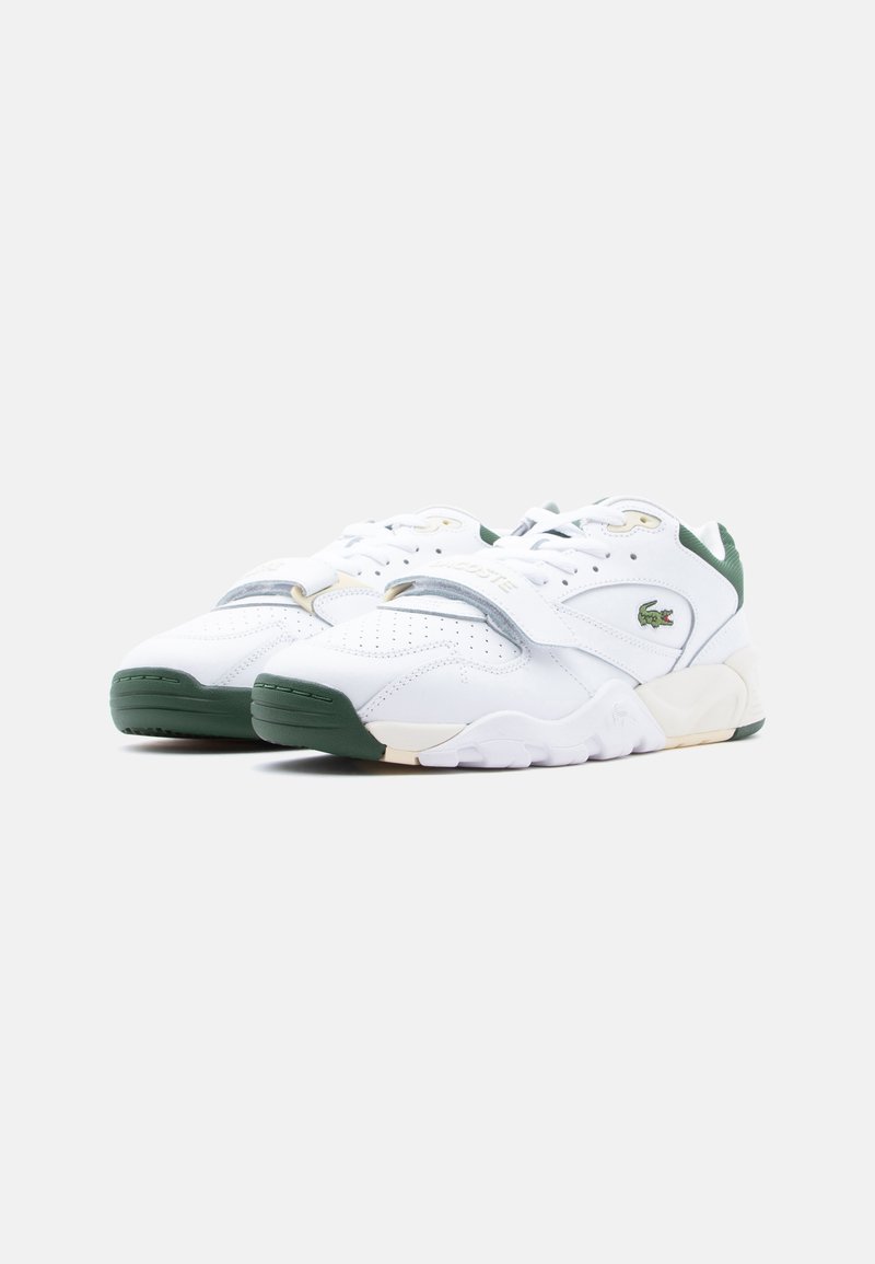 White and green Lacoste sneakers with laces and a Velcro strap, featuring perforated detailing and the Lacoste crocodile logo on the side.