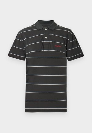 Czarna koszulka polo z białymi i niebieskimi poziomymi paskami, klasyczny kołnierzyk, dwa guziki oraz czerwone logo na piersi. Materiał z mieszanki bawełny.