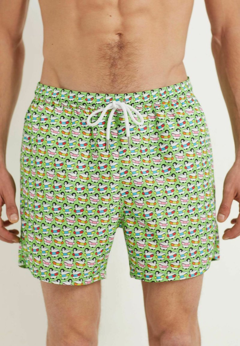 Pantaloni de baie verzi cu un model de rățuște colorate din cauciuc. Talie elastică cu șnur alb. Material ușor, respirabil.