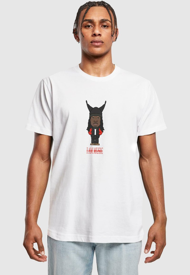 Hvid bomulds t-shirt med en tegneseriefigur, der har en sort beanie og røde detaljer. Teksten nedenfor siger "JEG ER MUSIK" med fede røde bogstaver.