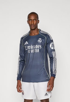 Maglietta da calcio a maniche lunghe di colore blu scuro con il logo "Emirates Fly Better", strisce Adidas sulle maniche e un piccolo emblema sul petto.