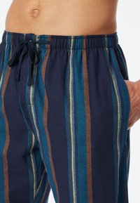 Navy striped pants made of lightweight fabric with elastic waistband, drawstring, and pockets featuring teal, brown, and green stripes.