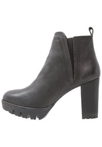 Botines de cuero negro con tacones altos en bloque, puntera redondeada, paneles laterales elásticos y suelas exteriores gruesas con dibujo para mayor tracción.