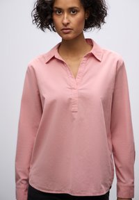 Roze blouse met lange mouwen, een kraaghalslijn en een gedeeltelijke knopenlijst, met een gladde textuur en een ontspannen pasvorm.