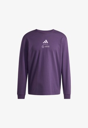 Fioletowa koszulka z długim rękawem wykonana z bawełny, z białymi logo Adidas i Mercedes na przodzie. Okrągły dekolt oraz ściągacze przy rękawach.