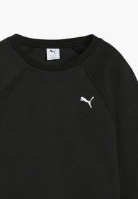 Čierna mikina s raglanovými rukávmi, mäkká textúra a biele logo Puma na ľavej hrudi. Má okrúhly výstrih a pevnú šitie.