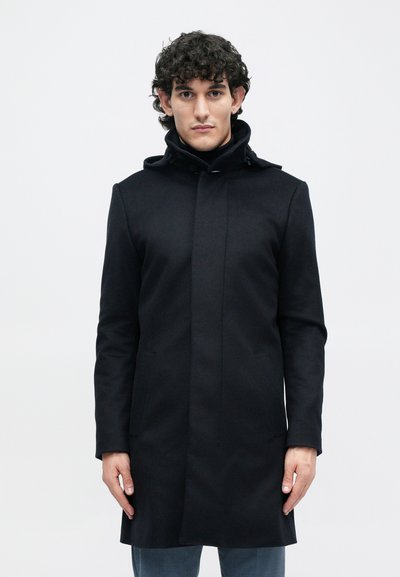 Cappotto nero in lana con colletto alto, cuciture delle tasche frontali e taglio dritto. Presenta un design pulito e minimalista, adatto a diverse occasioni.