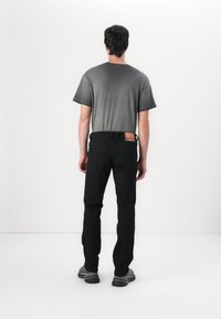Hallid ümar kaelusega t-särk, mustad teksad ja hallid spordijalatsid. Teksad on varustatud tagakoti sildiga ja slim fit disainiga. Sile kangastekstuuri.