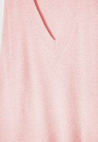Pull tricoté rose doux avec un col en V profond et une texture côtelée fine.
