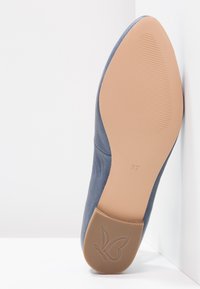 Podrážka modré kožené boty s béžovým dnem, velikost 37, s motivem motýla na gumové nálepce na patě.