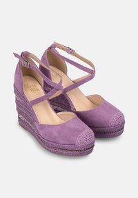 Scarpe con zeppa in suede viola, con cinturini incrociati alla caviglia, punta arrotondata, suola intermedia intrecciata testurizzata e dettagli metallici decorativi.