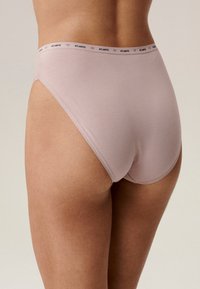 Jasnoróżowe bawełniane majtki typu brief z wysokim stanem, z kontrastowym elastycznym pasem, na którym znajduje się napis "ATLANTIC" małymi literami. Gładka faktura.