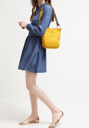 Denim kjole med samlet talje, lange ærmer; sennepsgul crossbody taske; metalflade sko med struktureret overflade; afslappet outfit.