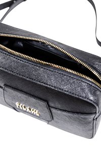 Borsa a tracolla nera con texture, zip dorata, tasca frontale e logo "1°CLASSE" dorato su sfondo bianco.