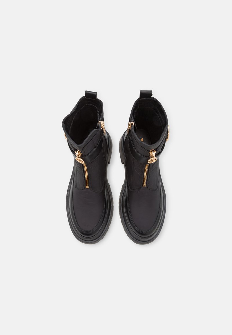 Schwarze Knöchelstiefel mit goldenen Reißverschlüssen, ausgestattet mit einem glatten Lederobermaterial, gummierter Sohle und gepolstertem Kragen, die ein abgerundetes Zehen-design präsentieren.