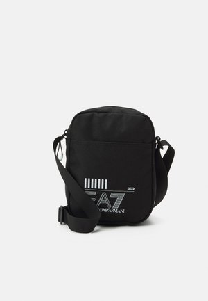 Borsa a tracolla nera in tessuto con strap regolabile, forma rettangolare, caratterizzata da un logo stampato bianco e dettagli con strisce orizzontali.