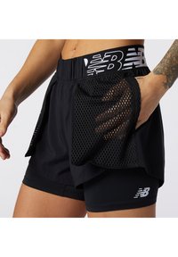 Pantalones cortos deportivos negros con una ancha cinturilla elástica que presenta un logo blanco, bolsillos laterales de malla, y una capa interna ajustada para soporte.