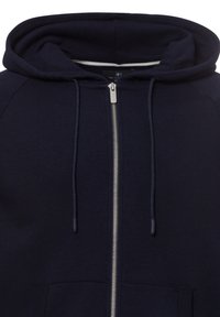 Navy blue zip-up hoodie made of soft fabric, featuring a textured hood, front pockets, and a silver zipper detail.