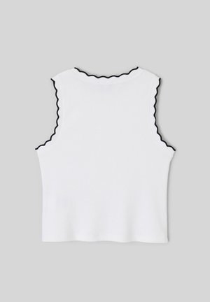 Haut blanc sans manches à côtes avec un bord ondulé noir le long de l'encolure et des emmanchures sur un fond gris uni.