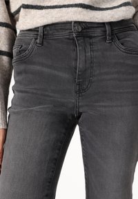 Gray denim jeans with a slim fit, featuring a mid-rise waist, front pockets, and a subtle faded texture. Button closure at the waistband.