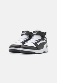 Zwart-witte mid-top sneakers met een leren buitenkant, een gepolsterde kraag, witte veters en een klittenband met het Puma-logo.