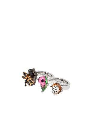 Tres anillos con diseños de flores e insectos. Los materiales incluyen plata y gemas de colores en tonos rosa, verde, ámbar y acentos negros.
