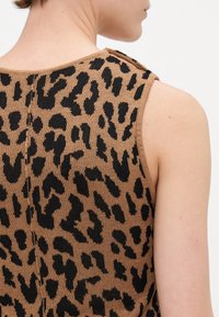 Strikket tanktop med brun og svart leopardmønster, ermeløs design, rund hals og synlig skulderknapppynt.