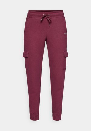 Burgundské tepláky s elastickým pasem, šnůrkou, bočními kapsami a elastickými manžetami. Měkká, strukturovaná tkanina s casual designem.
