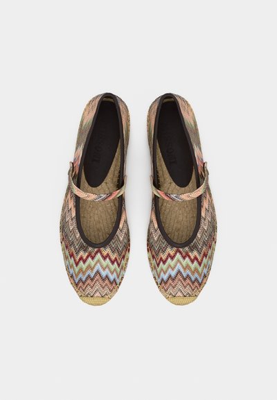 Ζευγάρι επίπεδα παπούτσια Mary Jane με πολύχρωμο ζιγκ ζαγκ σχέδιο και πλεκτή μύτη, από πάνω σε λευκό φόντο.