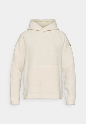 Kremowy polarowy sweatshirt z kapturem, kieszenią z przodu, rękawami raglanowymi oraz haftowanym logo na prawym rękawie. Miękka tekstura.