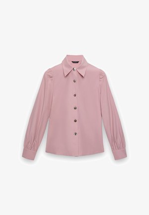 Blouse rose clair à manches longues avec épaules bouffantes, boutons décoratifs en argent au centre, col large et manches avec poignets.