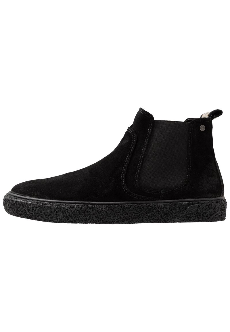Stivaletti alla caviglia in suede nero con pannelli elastici laterali, suola in gomma nera texturizzata e linguetta per il pull, caratterizzati da materiali lisci e morbidi.