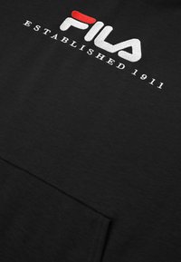Felpa nera con logo FILA ricamato in bianco, con accento rosso, e "ESTABLISHED 1911" in testo bianco. Tessuto morbido.