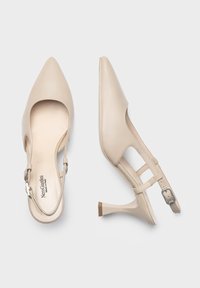 Tacchi slingback beige con punta appuntita, realizzati in pelle liscia. Caratterizzati da un tacco sottile e una cintura regolabile con una fibbia metallica decorativa.