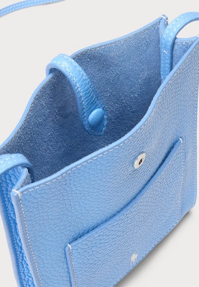 Torba za prenašanje iz svetlo modrega usnja z teksturirano površino, ki ima sprednji žep, zaponko na pritisk in dve zgornji ročaji za enostavno nošenje.