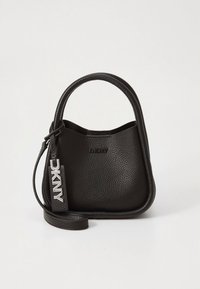 Czarna skórzana torebka o fakturowanej powierzchni, zaokrąglonym kształcie i górnym uchwycie. Posiada odpinany pasek oraz srebrną zawieszkę z logo DKNY.