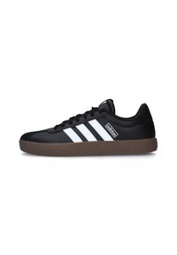 Zapatillas deportivas negras con franjas blancas, un diseño elegante, suela de goma y parte superior texturizada. La marca en el lateral es mínima y sutil.