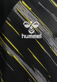 Sort atletisk stof med gule og grå abstrakte mønstre, med en hvid "hummel"-logo i midten. Glat, struktureret overflade.