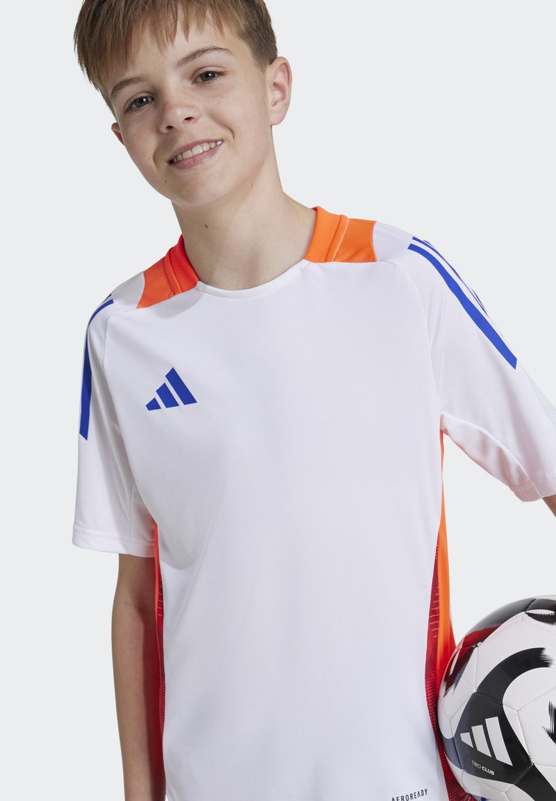 Camisa desportiva branca com detalhes em laranja e azul, mangas curtas e gola redonda. Apresenta o logotipo da Adidas e inclui uma bola de futebol estampada.